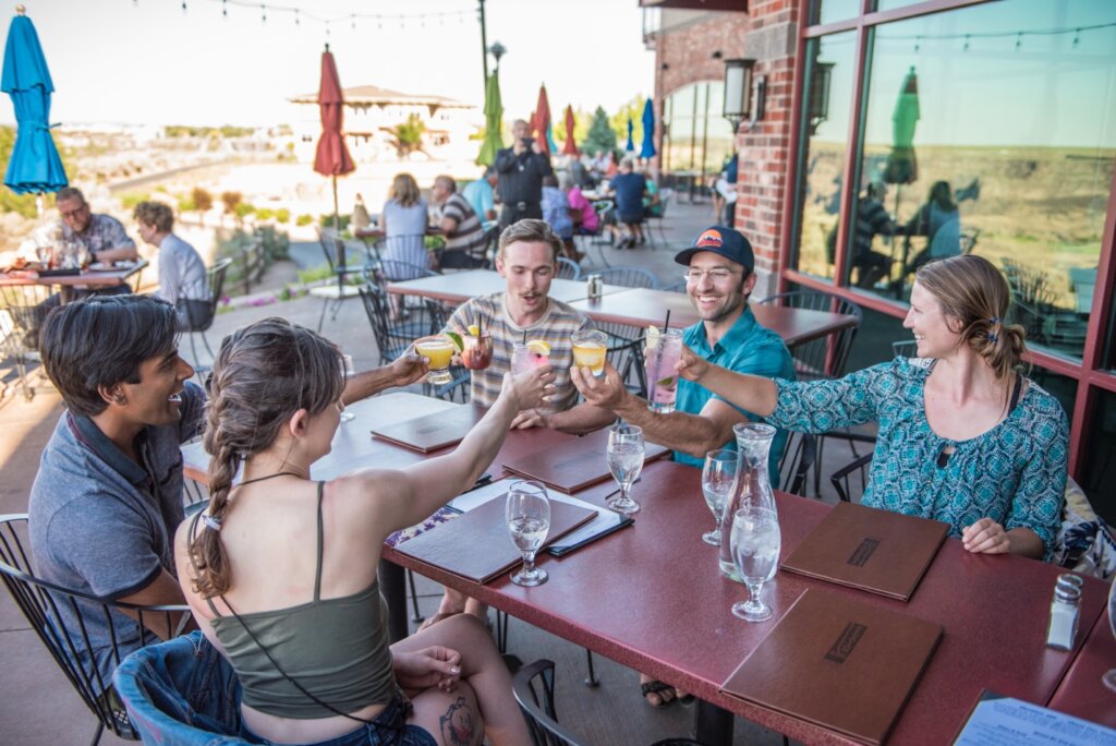 Diners toasting drinks on the patio at Elevation 486 in Twin Falls